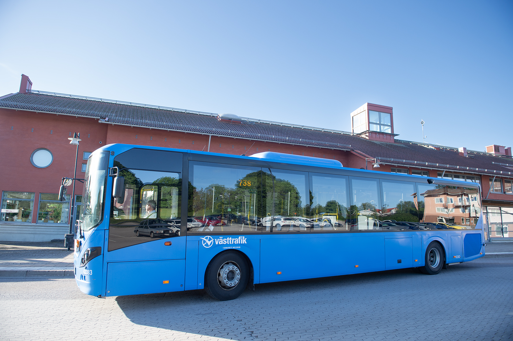 En blå västtrafikbuss framför centrumhuset i Färgelanda